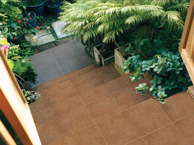 ประตูลายไม้ บันไดลายหิน สู่พื้นดินในสวนร่มรื่น