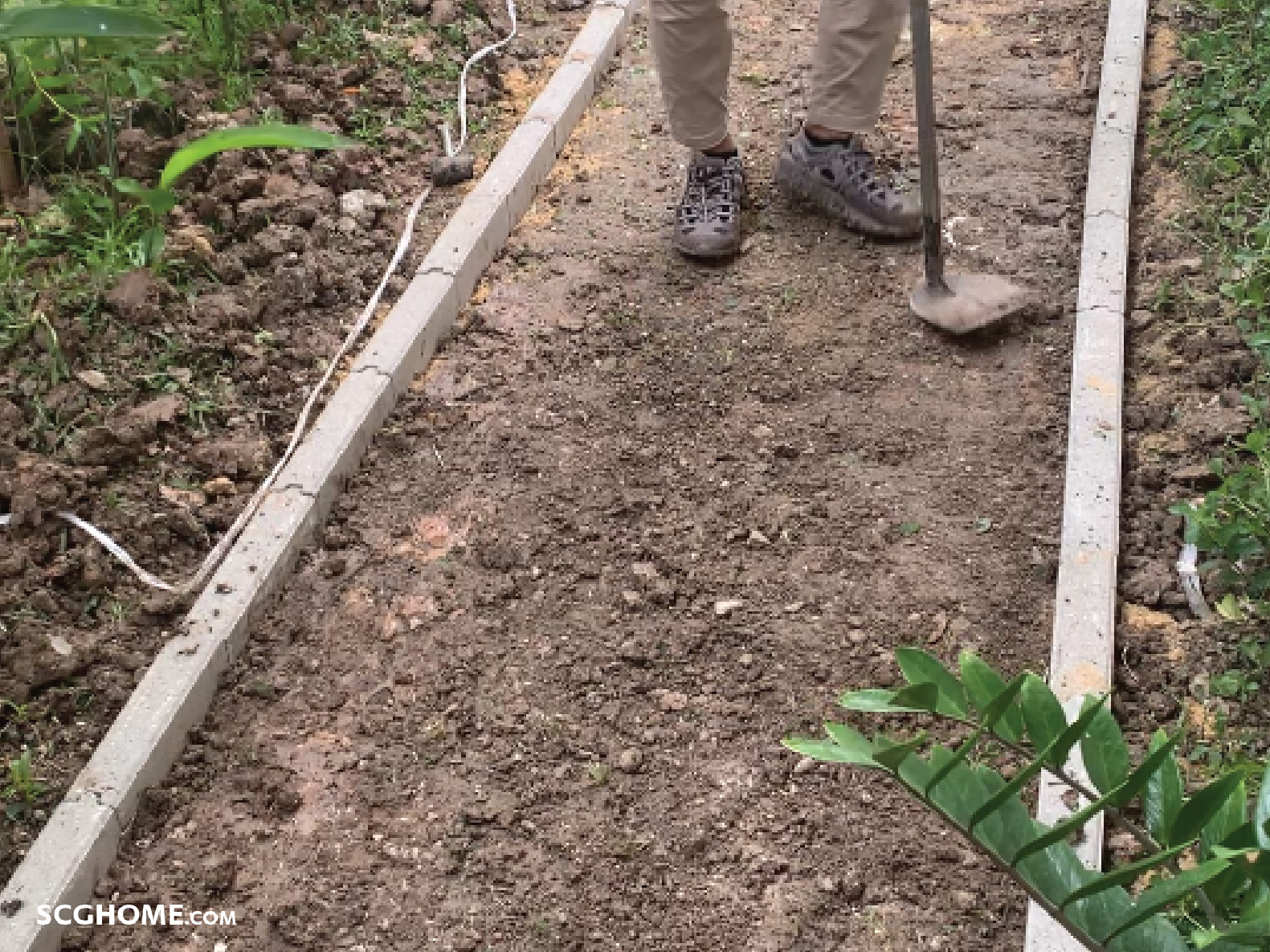 ใช้จอบช่วยกระทุ้งบดอัดดิน